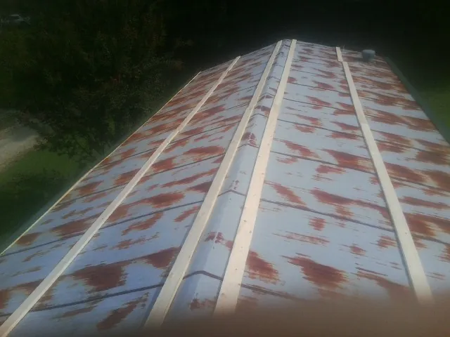 Rusted metal roof panels with new wood purlins before replacement — Storm Damage Roof Repair in Weems by Roofing Brothers