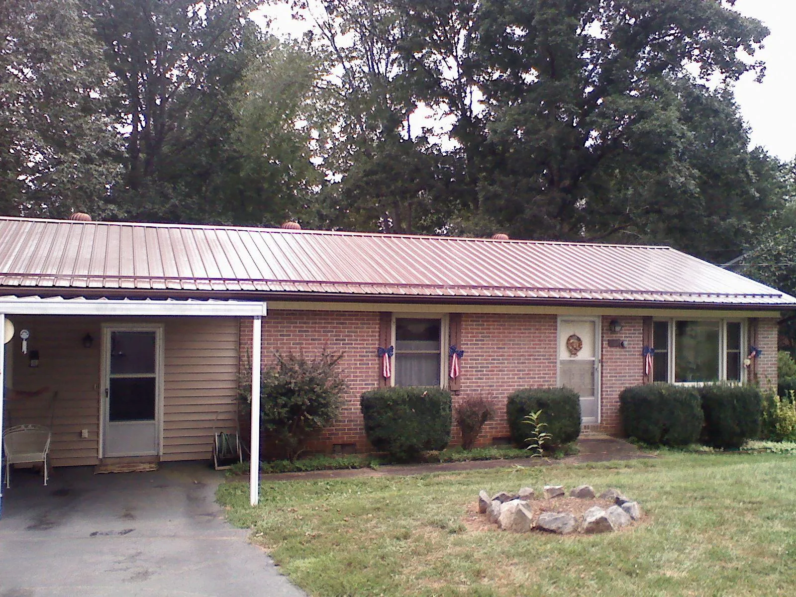 Bronze metal roof and carport on a brick ranch home — Roof Repair work by our crew in Weems