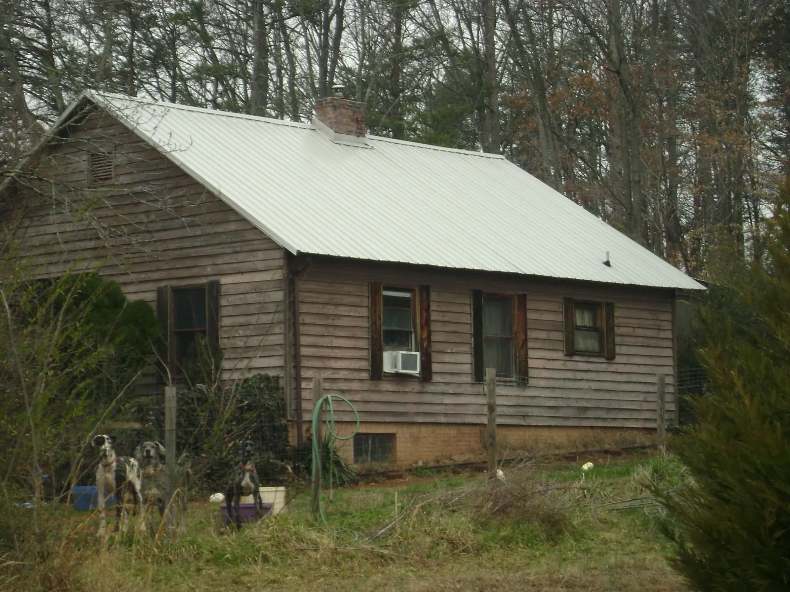 White metal roof on an old wood sided farmhouse, from a Metal Roof Installation job in Weems
